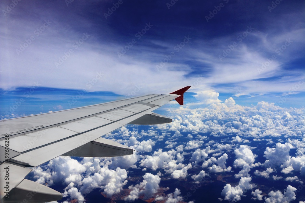 Wing of an airplane flying above the clouds Wing of an airplane flying above the clouds