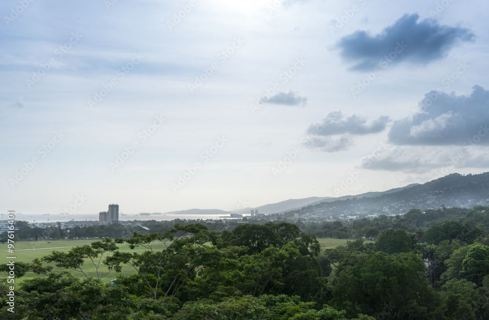 Distant view of city with mountain against cloudy sky, Trinidad, Trinidad And Tobago Distant view of city with mountain against cloudy sky, Trinidad, Trinidad And Tobago