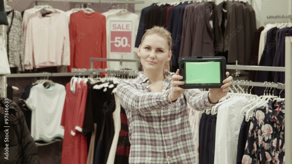 The seller shows the tablet with the green screen in mall The seller shows the tablet with the green screen in mall
