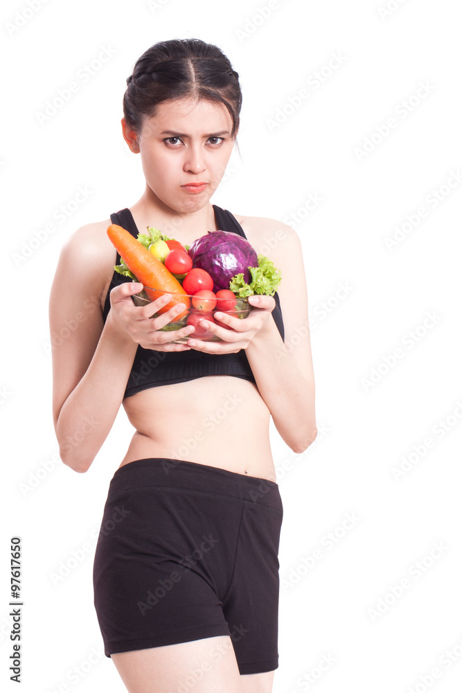 young woman with vegetables with a expression of disgust and boredom young woman with vegetables with a expression of disgust and boredom