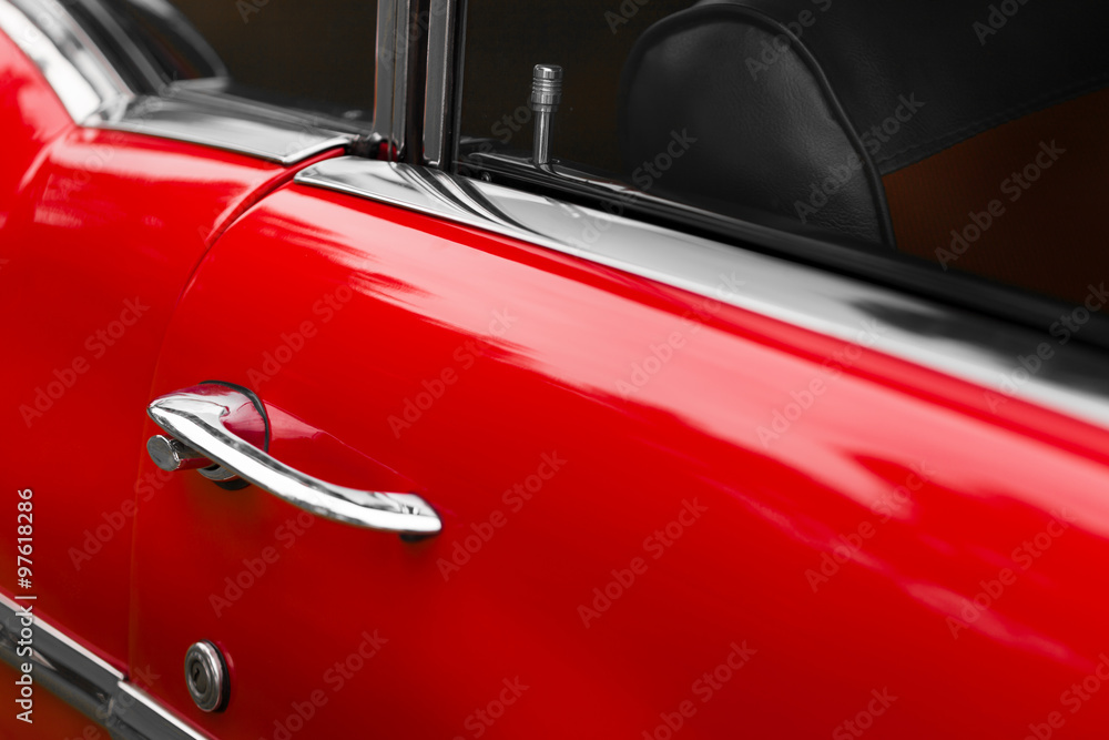 Close-up of car door lock pin of a red shiny classic vintage car