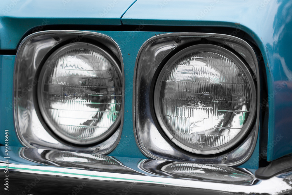 Close-up of right headlights of a blue classic vintage car