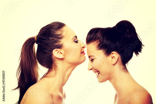Woman kissing friend in forehead.