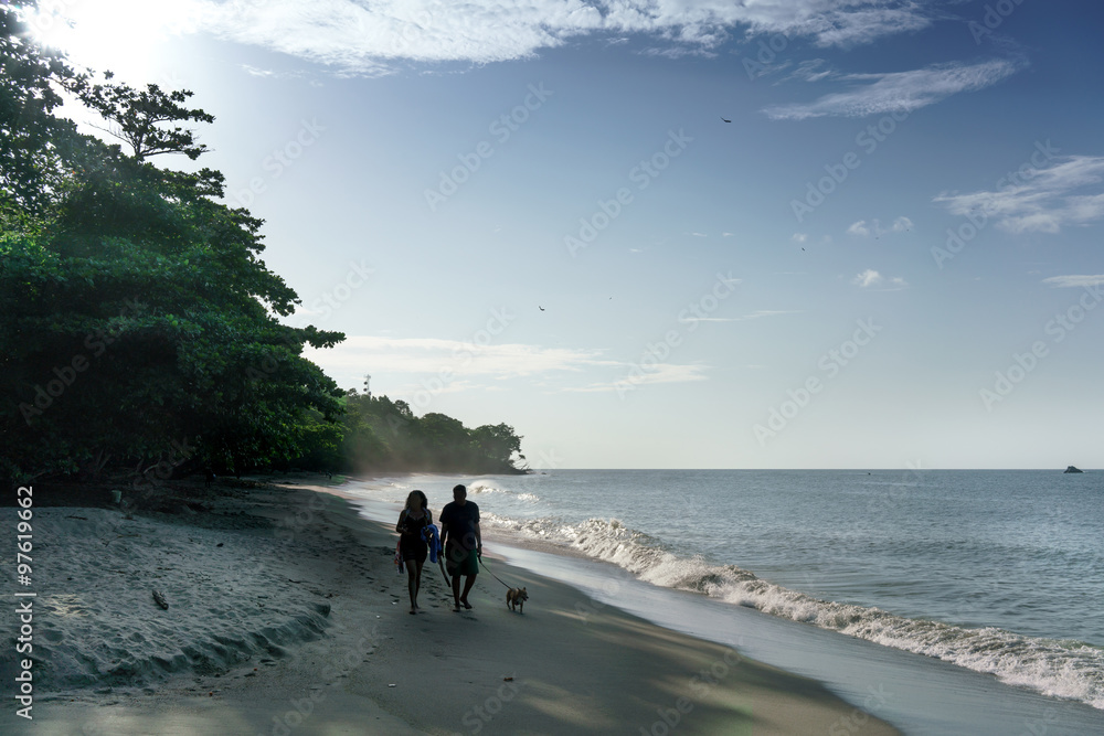 Couple with dog walking on sandy beach, Trinidad, Trinidad and Tobago Couple with dog walking on sandy beach, Trinidad, Trinidad and Tobago