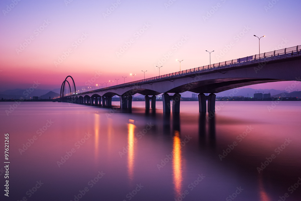 sunrise skyline and reflection of bridge over river sunrise skyline and reflection of bridge over river