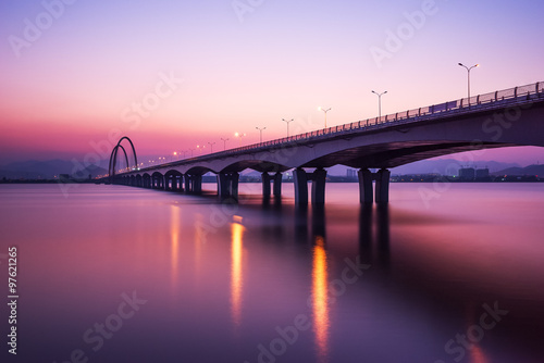 Fototapeta Naklejka Na Ścianę i Meble -  sunrise skyline and reflection of bridge over river