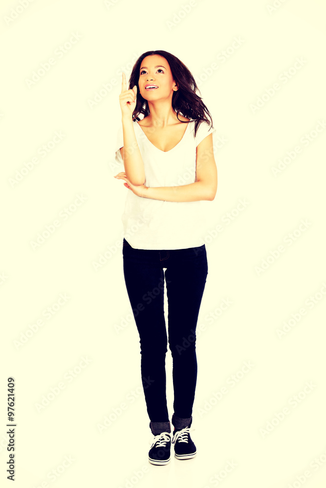Fototapeta premium Young woman pointing up.