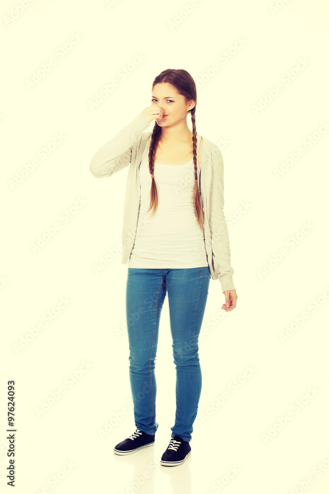 Disgusted teen woman pinching nose. Disgusted teen woman pinching nose.
