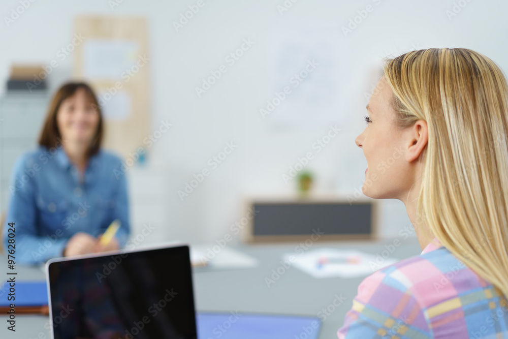frau unterhält sich mit einer kollegin im büro frau unterhält sich mit einer kollegin im büro