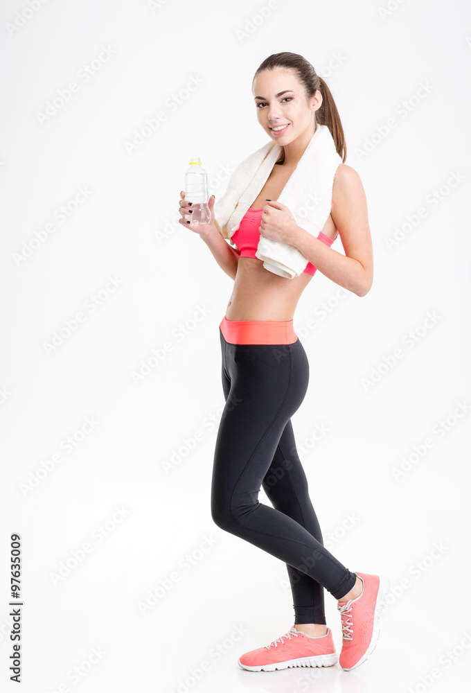Fitness woman posing with white towel and bottle of water Fitness woman posing with white towel and bottle of water