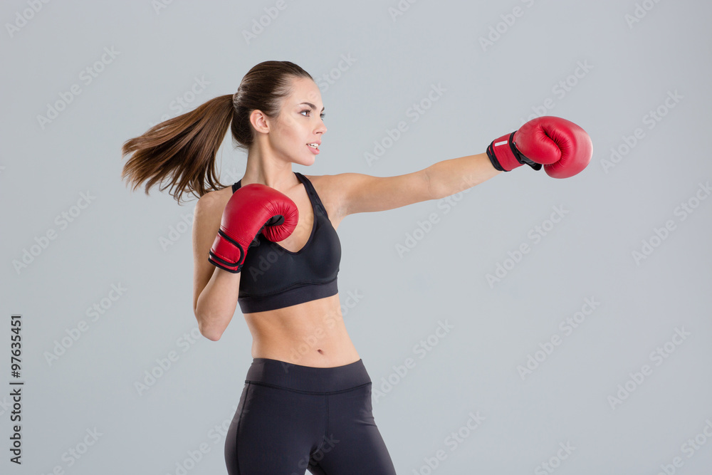 Profile of beautiful young boxing sportswoman in red gloves