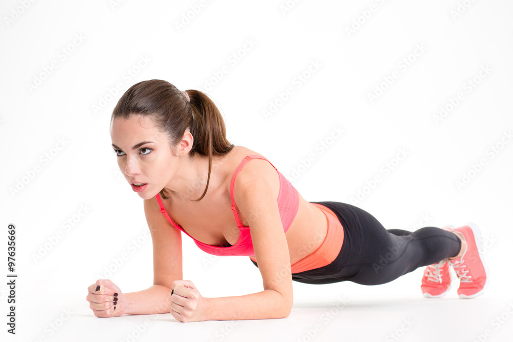 Concentrated beautiful fitness girl in sportwear exercising doing plank Concentrated beautiful fitness girl in sportwear exercising doing plank