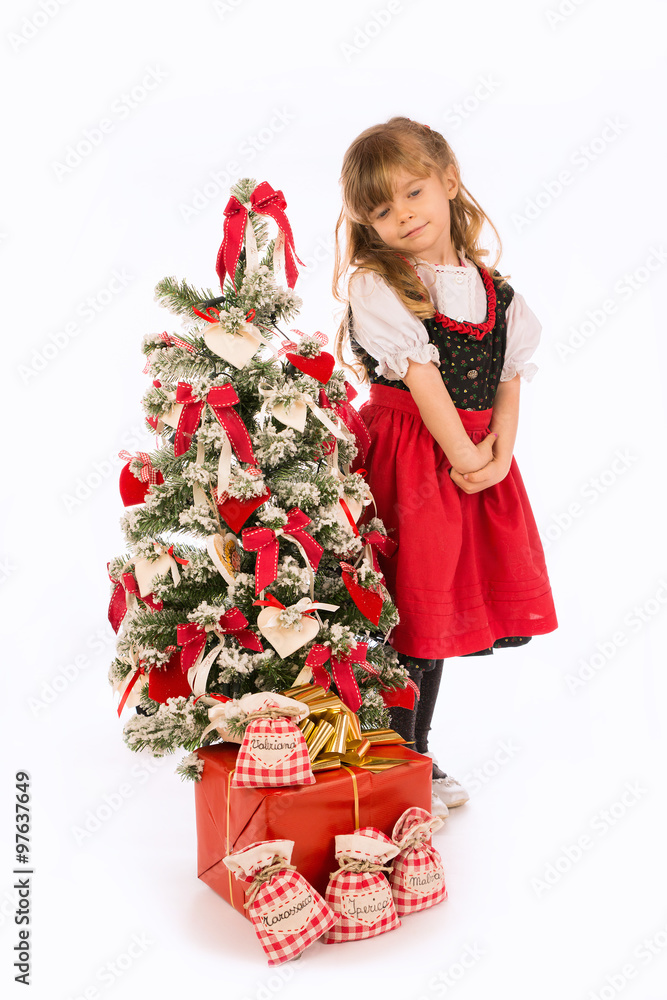 Bambina in piedi con albero di Natale e addobbi
