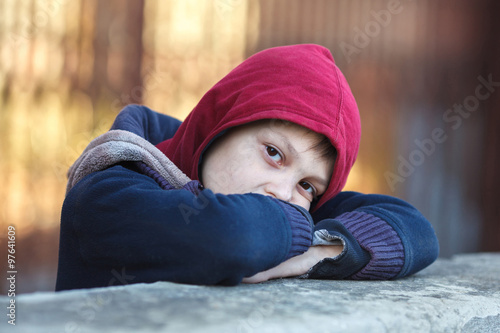 dramatic portrait of a little homeless boy