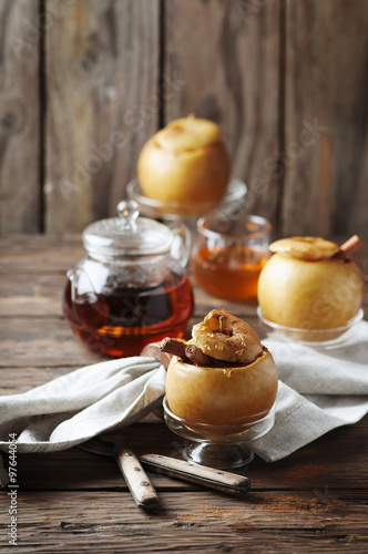 Baked apples with honey and cinnamon on the wooden table