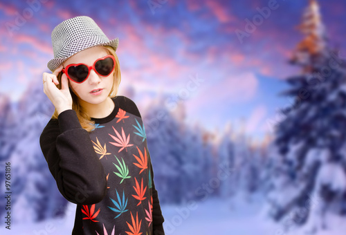 Pretty girl in sunglasses happy smiling on winter forest background