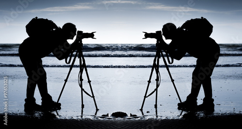 Obraz na plátne Mirror imaged silhouette of a photographer on a Gower beach in South Wales