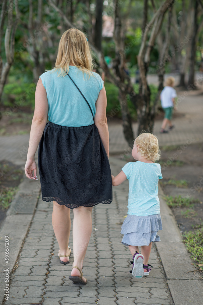 Hands of mother and daughter holding each other in garden Hands of mother and daughter holding each other in garden