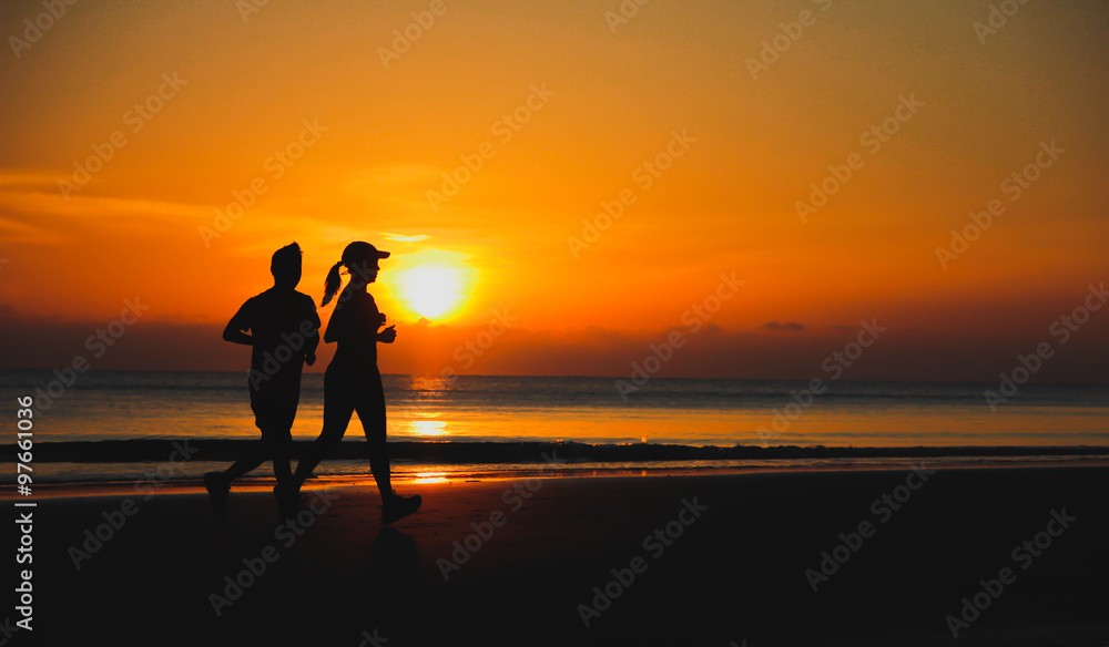 Young couple: man and woman run together on a sunset on lake coa
