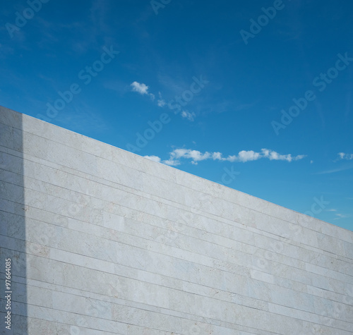 White marbled wall and blue sky with tree 
