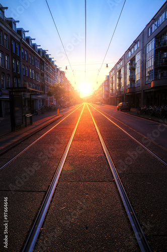 Early morning sunrise on the streets of Amsterdam with a nice perspective and depth with the tram rails