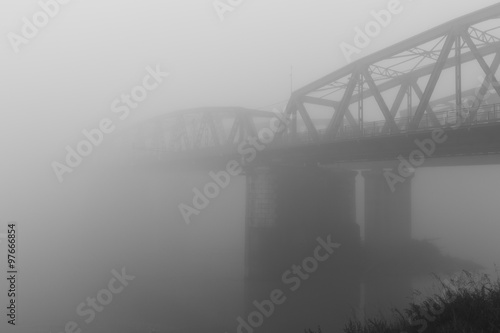 old iron bridge over wrapped in a mysterious fog