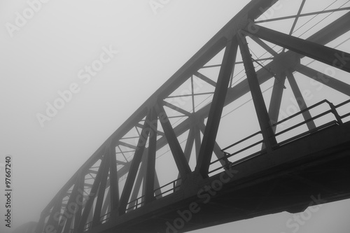 old iron bridge over wrapped in a mysterious fog