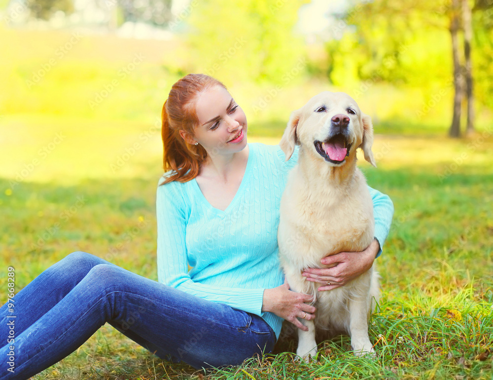 happy owner woman and Golden Retriever dog sitting on grass toge happy owner woman and Golden Retriever dog sitting on grass toge