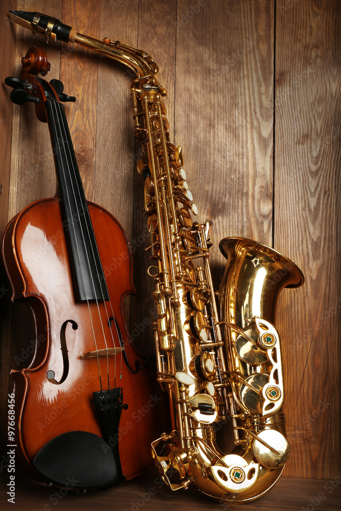Close up musical instruments: saxophone, violin in wooden box foto de Stock Adobe Stock