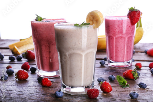 Glasses of fresh cold smoothie with fruit and berries, isolated on white