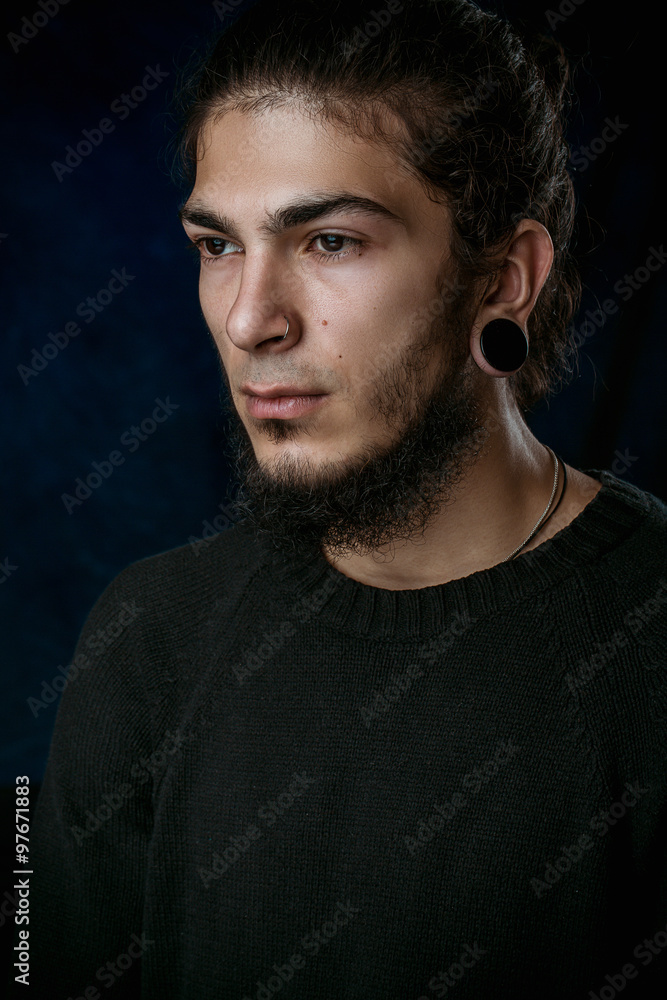 Fototapeta premium brutal young man with a beard against a dark background