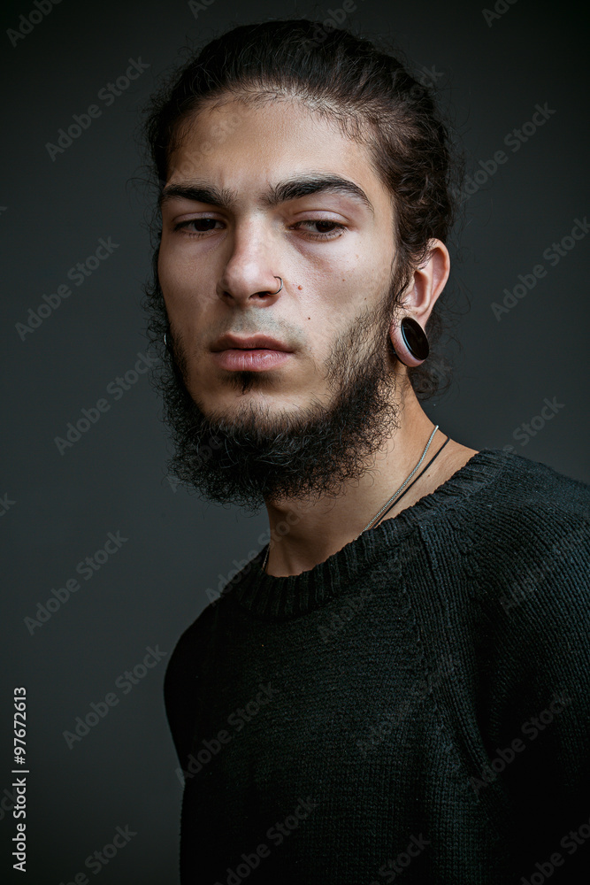 brutal young man with a beard against a dark background