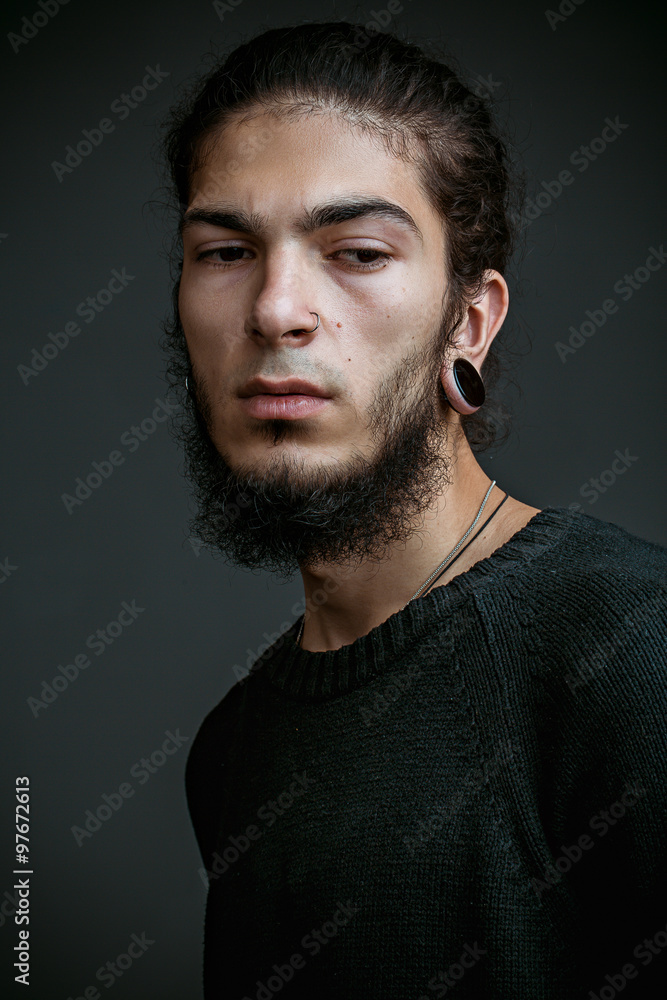 brutal young man with a beard against a dark background brutal young man with a beard against a dark background
