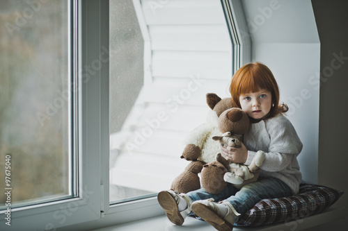 Girl with a toy sitting on the windowsill 4383.