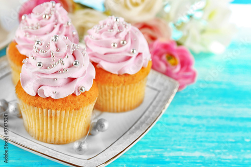 Fototapeta Naklejka Na Ścianę i Meble -  Cake with sugar paste flowers and cupcakes, on light background