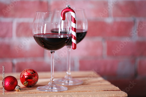 Two glasses of wine with christmas toys on wall background © Africa Studio