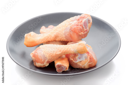 raw chicken thighs in dark porcelain dish