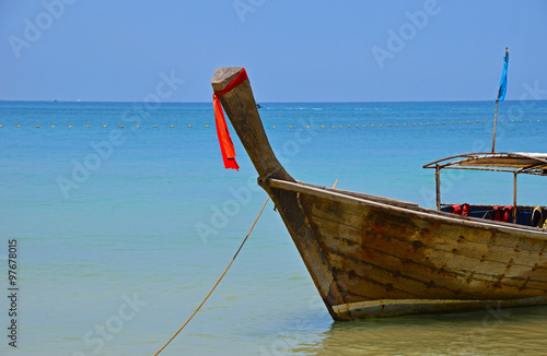 Traditional Thailand old long tail boat in transparent water