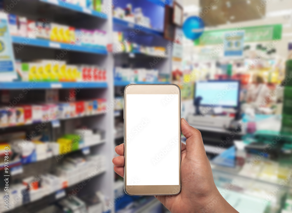 Hand with smartphone on blurred in pharmacy Hand with smartphone on blurred in pharmacy