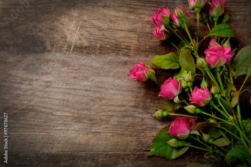 Beautiful bouquet of pink little roses on wooden background  copy space