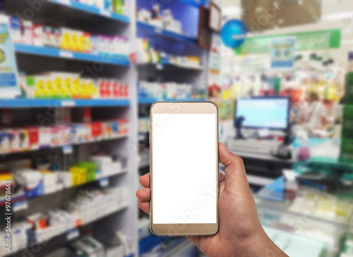 Hand with smartphone on blurred in pharmacy