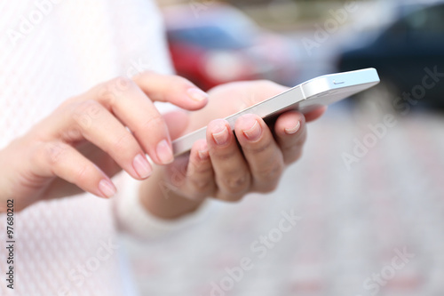 Woman holding smartphone outside