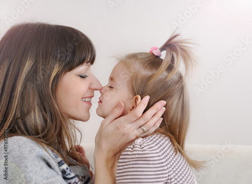 Photography nose to nose mother and her little daughter playing and having f