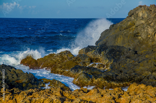 Waves crashing on the rocks of Aruba, ABC caribbean islands photo