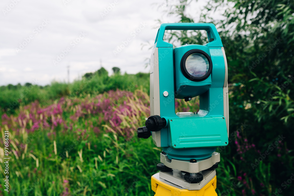 blue surveying   equipment total station on a background of meadow