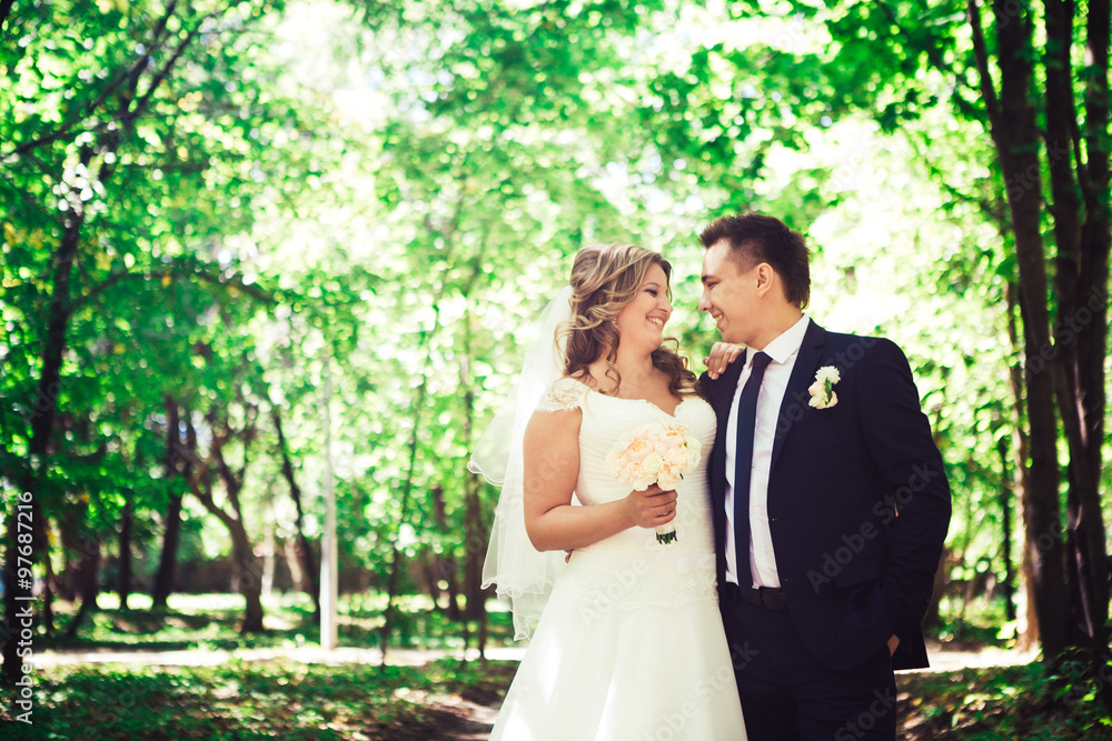 Happy couple bride and groom embracing they stand in a forest Happy couple bride and groom embracing they stand in a forest