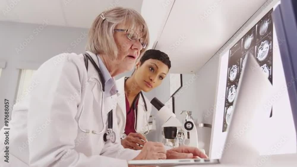 A couple of medical researchers looking through a microscope A couple of medical researchers looking through a microscope