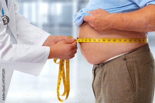 Doctor measuring obese man stomach. photo