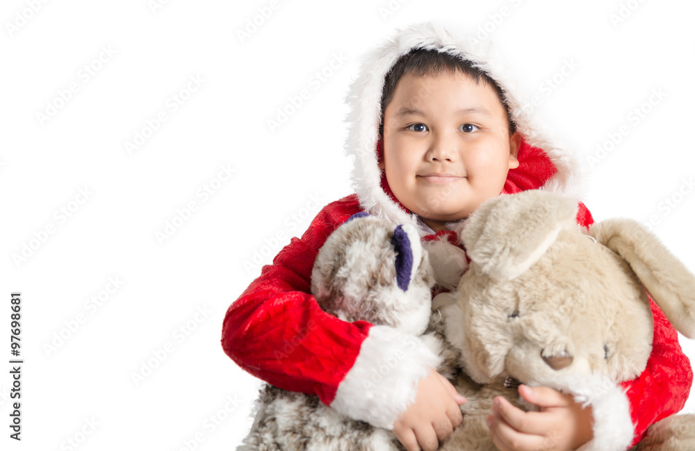 Fototapeta premium Little Asian fat boy in santa costume hugging rabbit doll on chr