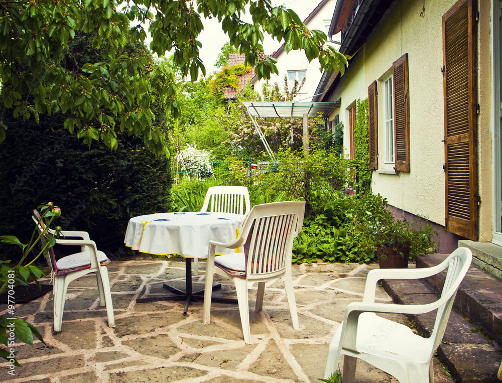 Patio with table and seats and garden view. Patio with table and seats and garden view.
